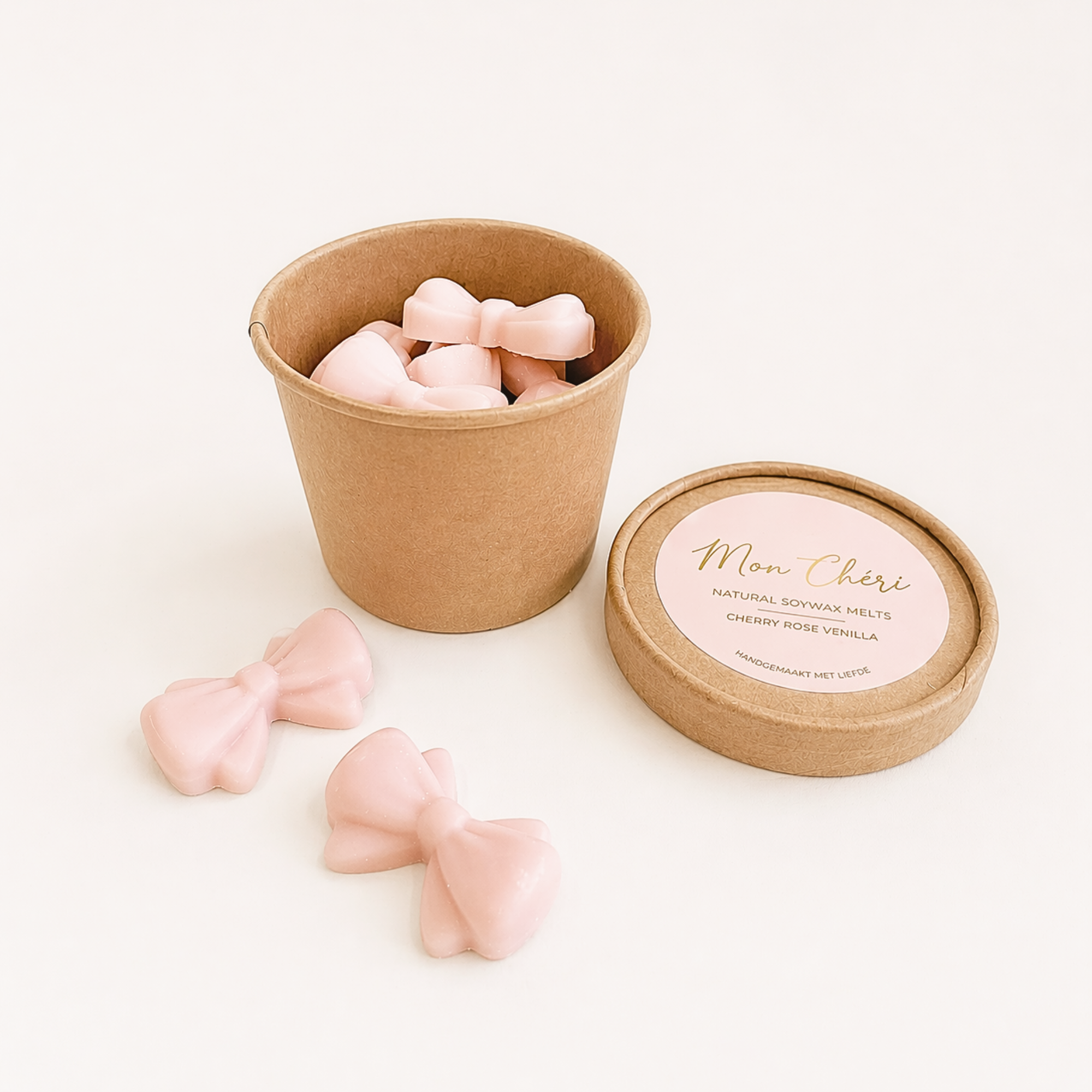 Mon Cheri wax melts in roze strikjes met kers, roos en vanille, verpakt in een rond kraftdoosje met labelsticker, lintje en gipskruid