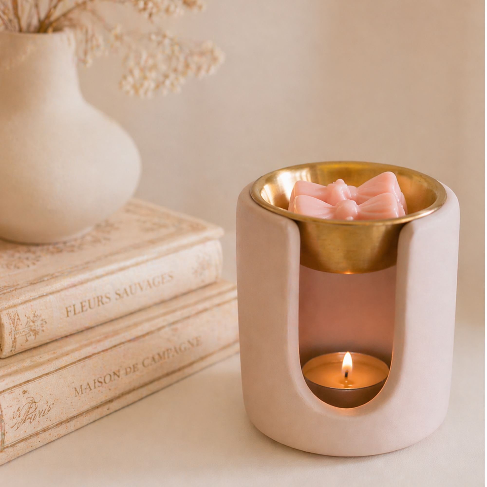 Handmade blush pink Loesieloe wax melt burner made from cast porcelain plaster with golden dish and small bow detail.